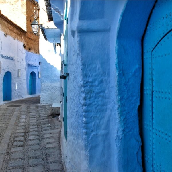A picturesque view of the iconic blue buildings along a narrow alley in Chefchaouen, Morocco.