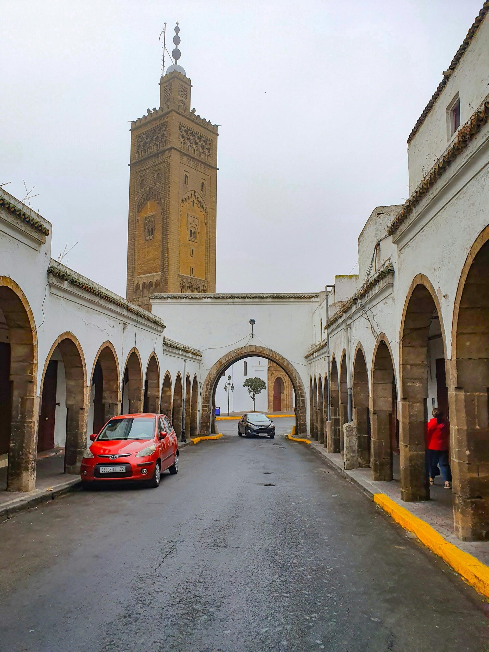 Stunning view of historic Moroccan arches and a towering minaret in Casablanca. Perfect for travel enthusiasts.