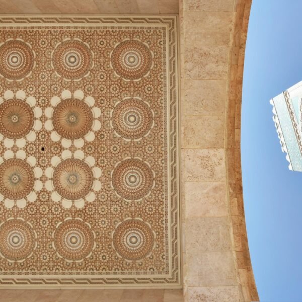 Intricate geometric ceiling art and iconic minaret of Hassan II Mosque in Casablanca, Morocco.